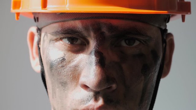 Portrait Dirty Mine Worker. Beautiful Caucasian Man in a Hard Hat. Filthy Job and Physical labor. Coal mining. People Working Equipment. Looking at Camera. Close up