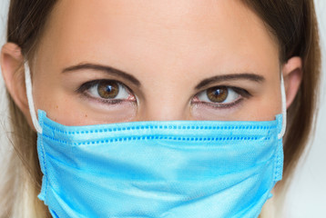 Close up portrait of female medical doctor or nurse wearing face medical protective mask