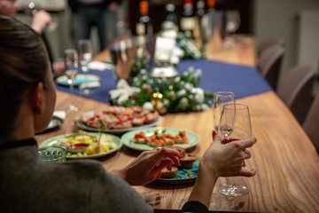 Young girl with a glass of wine at the table with snacks