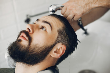 Man with a beard. Hairdresser with a client. Man wash a head