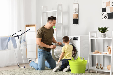 Man and his little son doing laundry at home