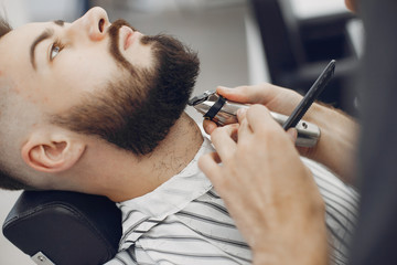 Man with a beard. Hairdresser with a client. Brunette in a barbershop