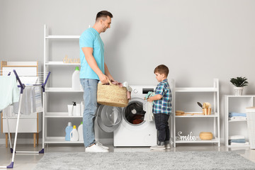 Man and his little son doing laundry at home