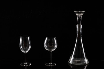 Wineglasses and decanter against black background