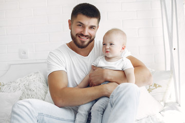 Fototapeta na wymiar Handsome dad with child. Man in a white t-shirt. Little boy in a bathroom