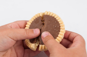 Chocolate cookies in children's hand isolated on white background.Copy space