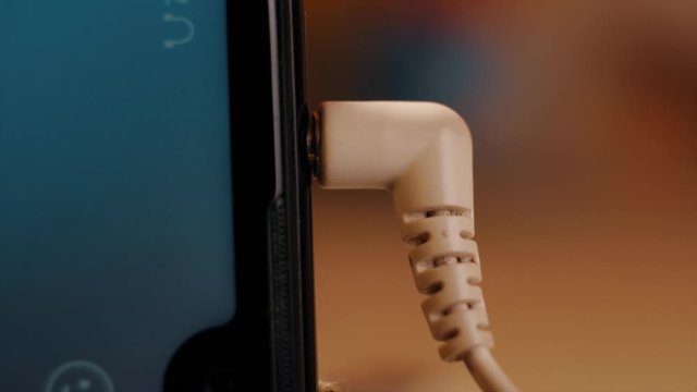 By connecting the headphones from the jack on the phone