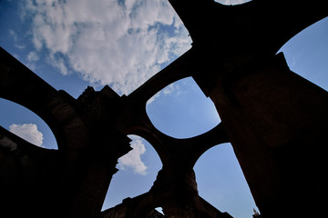 Silhouette of cathedral ruins against blue sky