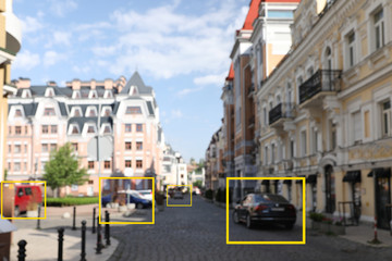 Naklejka na ściany i meble Blurred view of buildings and street with scanner frames on cars in city. Machine learning