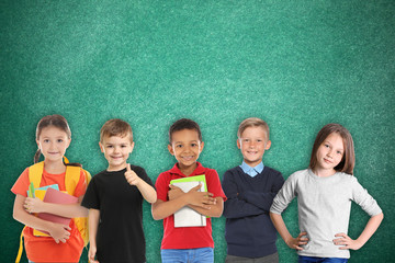 Fototapeta na wymiar Group of cute school children and chalkboard on background