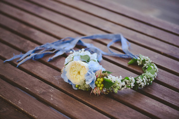 Rustic wreath with summer flowers on wooden background.