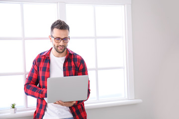 Young man with laptop working at home