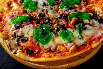 Traditional Italian pizza with tomatoes, mozzarella cheese, olives, corn and basil.