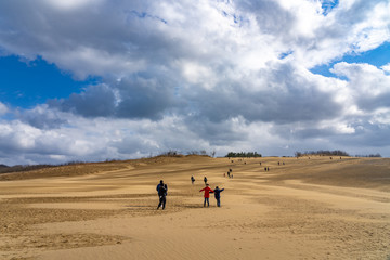 Fototapeta na wymiar Visitors are sightseeing in the Tottori Sand Dunes (Tottori Sakyu). The largest sand dune in Japan, a part of the Sanin Kaigan National Park. Tottori Prefecture, Japan