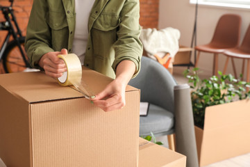 Woman packing moving box at home