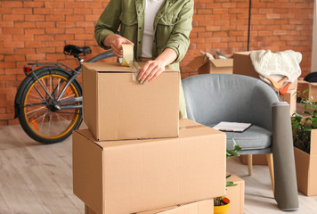 Woman packing moving box at home