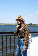 Girl in black protective medical mask is coughing.