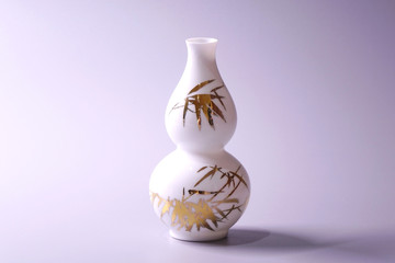 Antique Chinese Eggshell porcelain vase on grey color background. Golden bamboo leaves on White porcelain vase, famous Chinese antique pottery of Ming and Qing dynasties