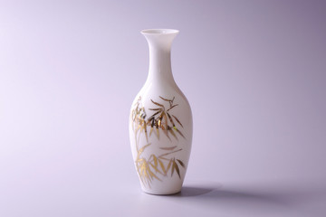 Antique Chinese Eggshell porcelain vase on grey color background. Golden bamboo leaves on White porcelain vase, famous Chinese antique pottery of Ming and Qing dynasties
