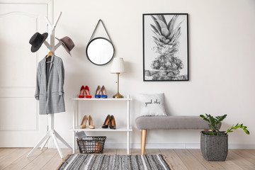 Stylish interior of modern hall with shoes on stand and bench