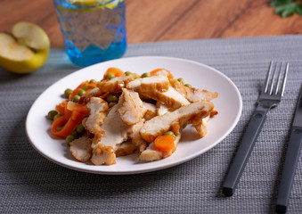roasted chicken meat with pea and carrot garnish - closeup