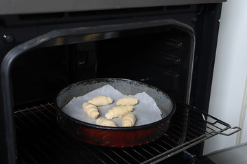 Homemade unbaked rolls in a casserole and ready for backing in the oven. The process of preparing homemade rolls pastry. Domestic and hand made food preparation concept. Close up, selective focus