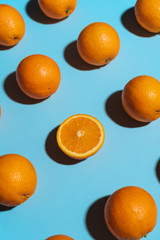 Fruit pattern with oranges on blue paper background. Angled top view. Summer concept