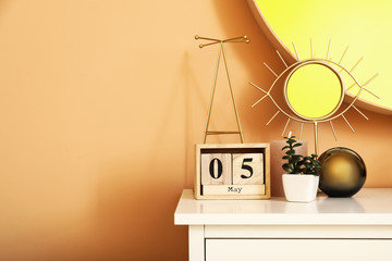 Calendar, mirror and decor on table in room
