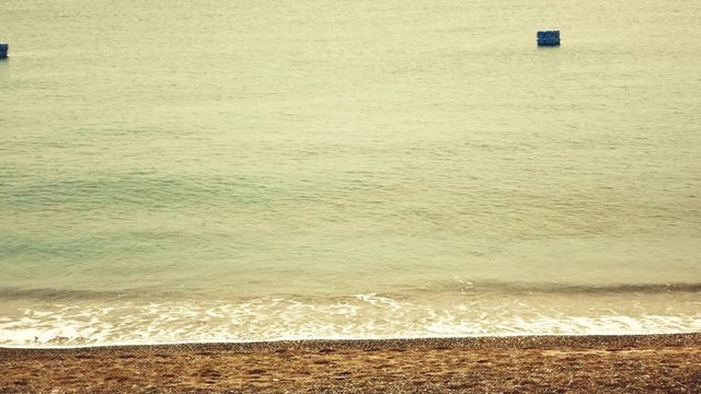 videos of sea waves crashing on the sand of the beach using a warm film