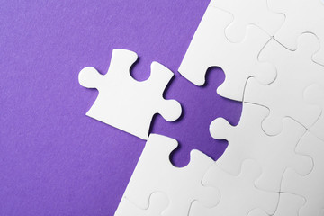 White puzzle with unfitting piece on purple background, flat lay