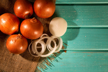 Fototapeta na wymiar Assorted farm fresh onions on a rustic wooden table with spring onions