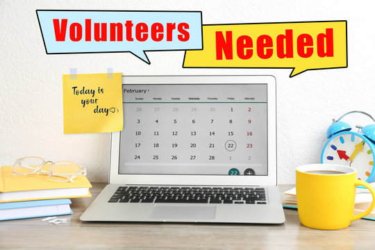 Modern laptop on wooden table in office. Volunteers needed