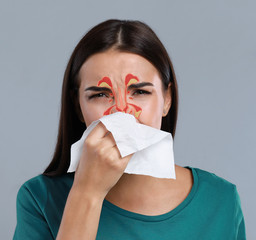 Woman suffering from runny nose as allergy symptom. Sinuses illustration on face