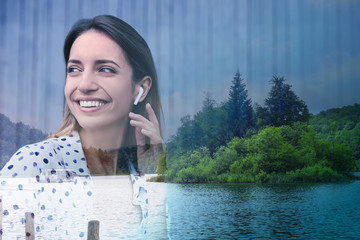 Double exposure of picturesque landscape and beautiful woman with wireless headphones listening to...