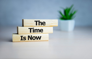The time is now - words from wooden blocks with letters, the time is now concept, top background.