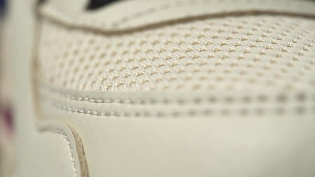 Extreme close up footage of perfect toe sneaker dolly in. Beige color.