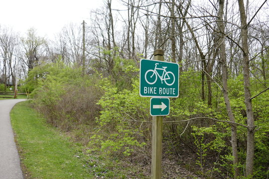 Bike route sign on paved path in public park