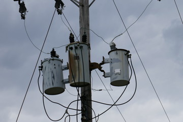 Telephone pole capacitors close-up against cloudy sky