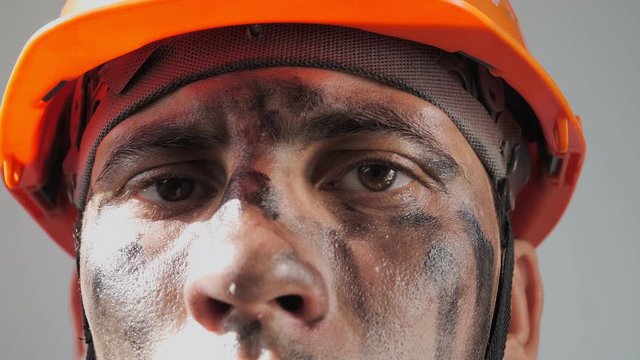 Portrait Dirty Worker Looking at Camera. Beautiful Caucasian Man in a Hard Hat. Filthy Job and Physical labor. Coal mining. People Working Equipment. Close up