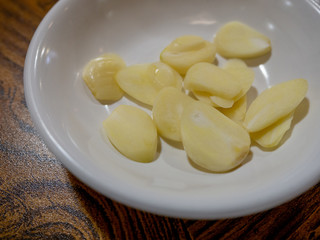 sliced garlic pieces in a white bowl.