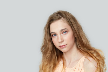 Fototapeta premium A young beautiful girl with blue eyes and long blond hair.