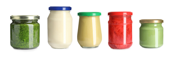 Set with delicious sauces in glass jars on white background. Banner design