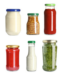 Set with delicious sauces in glassware on white background