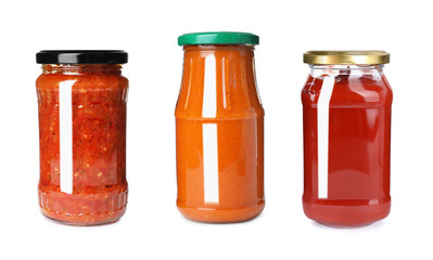 Set with delicious sauces in glass jars on white background