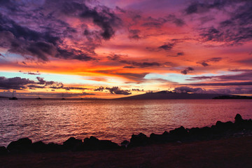 Dramatic sunsetn with fiery sky from Maui with Molokai in the distance.