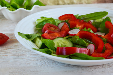 Healthy food. The concept of vegetarian food. Fresh vegetable salad with radish slices, red bell...