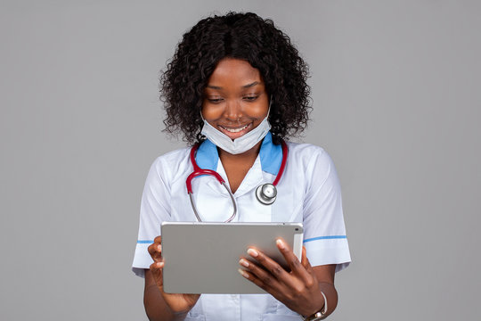 African American Female Medical Doctor Or Nurse Smiling And Holding Digital Tablet 