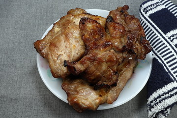 Pile of traditional grilled pork steak on the plate. Famous main course menu in party. 