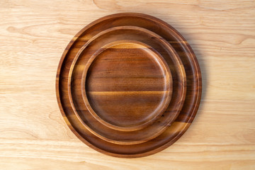 Round plate made of acacia wood, many layers on top of rubber wood with copy space