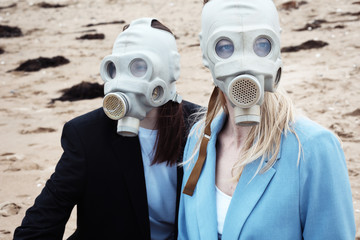Portrait of girls in gas masks on the beach. 
Quarantine summer 2020.